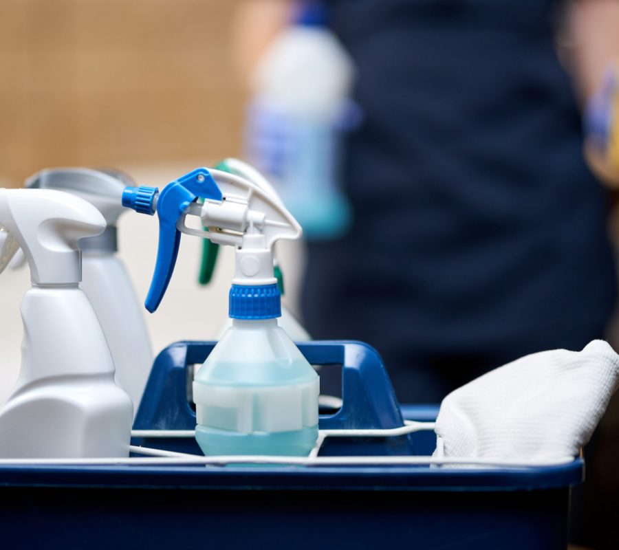 Close up of basket of cleaning tools for hotel room cleaning. Housekeeping and hygiene concept