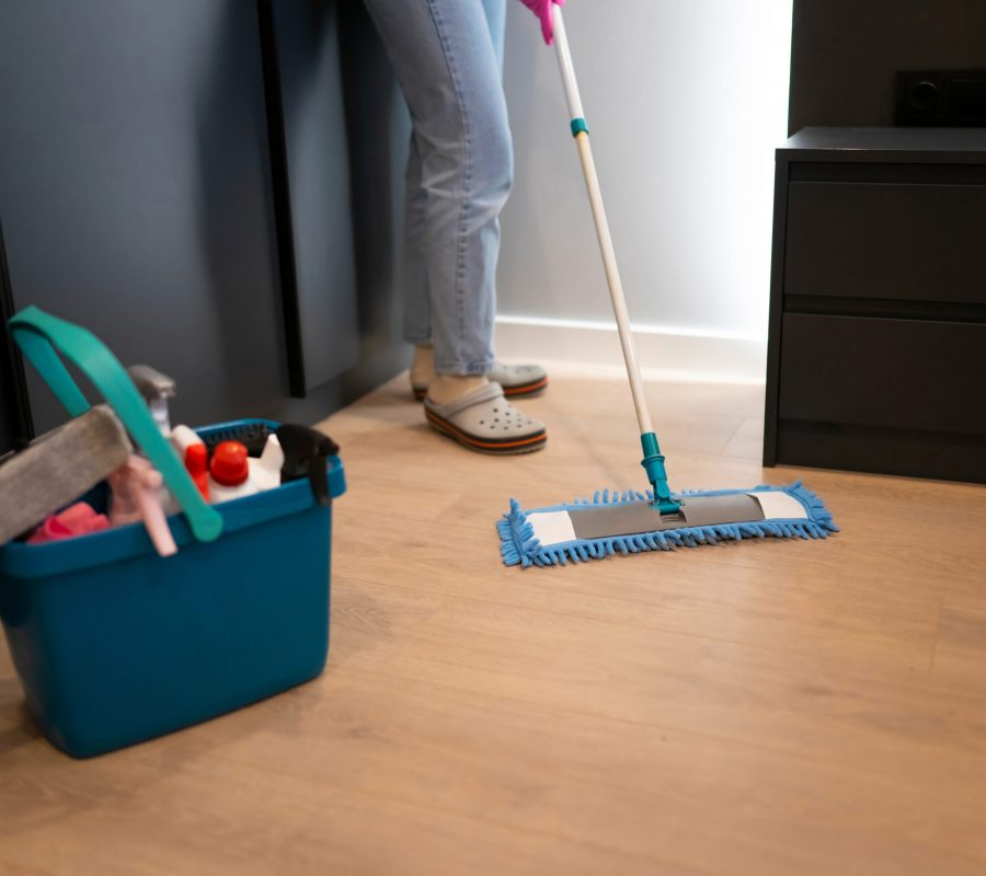 Woman mopping floor in bedroom